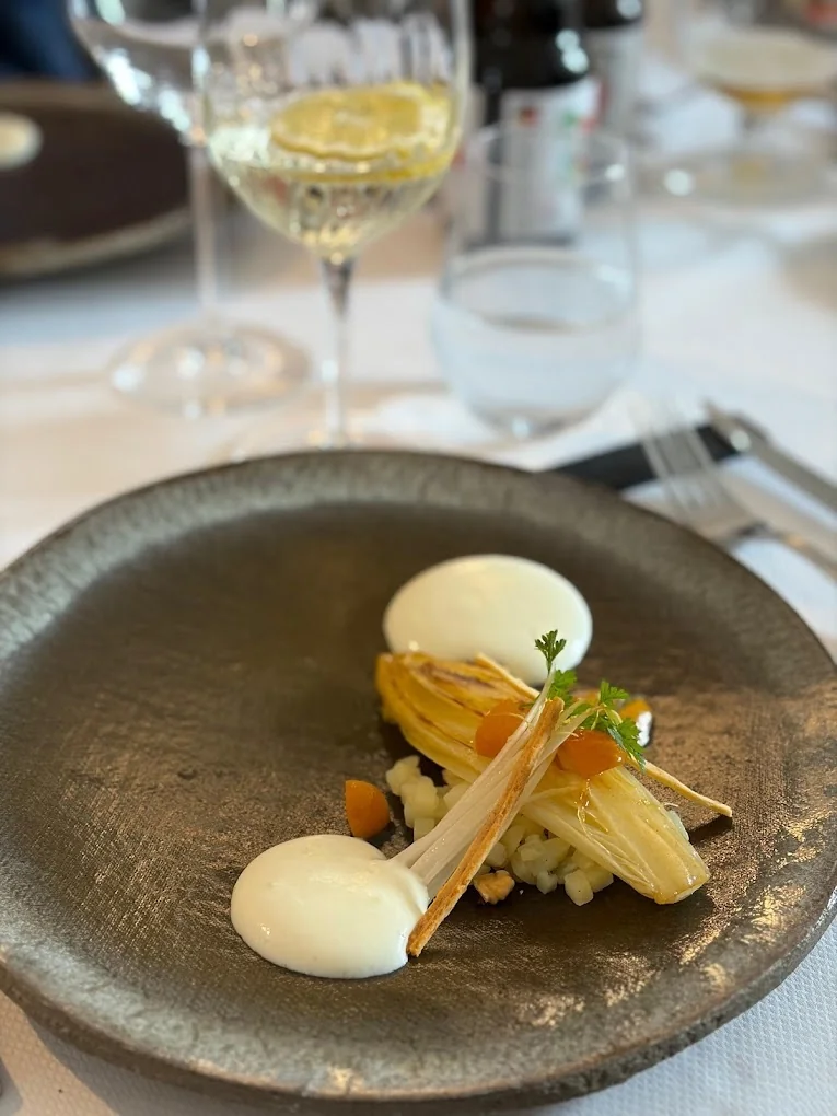 Assiette gastronomique d'endives confites avec mousse au restaurant brut.