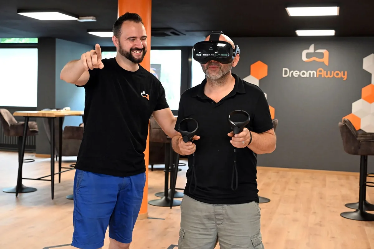 Game master DreamAway accompagnant un joueur équipé d'un casque de réalité virtuelle dans la salle de Saint-Nazaire