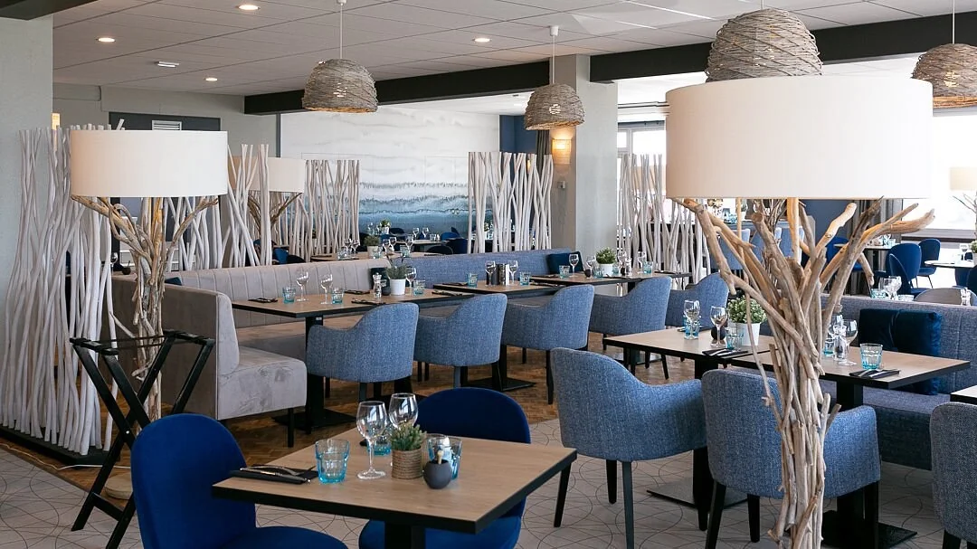 Salle moderne de La Flottille avec bois flotté et chaises bleues