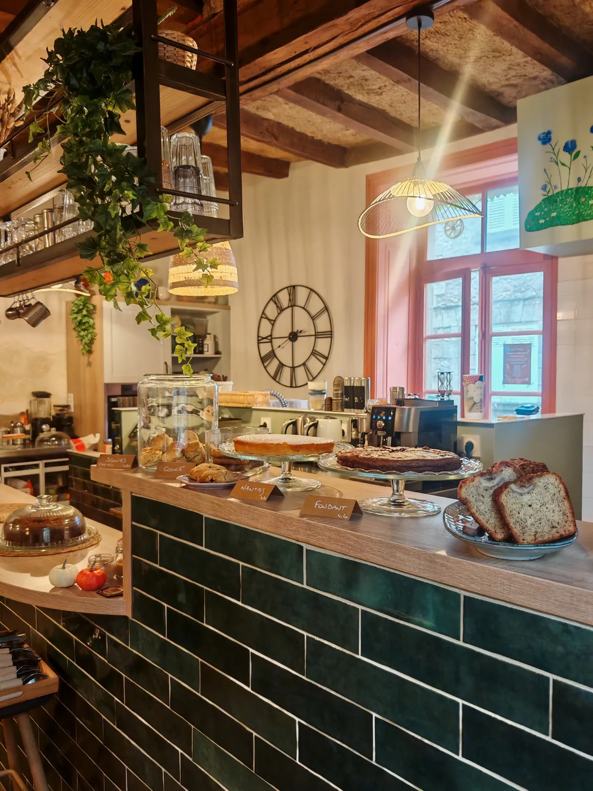 Comptoir du salon de thé Le Gout'Thé à Guérande avec pâtisseries maison sur présentoirs et faïences vert sapin
