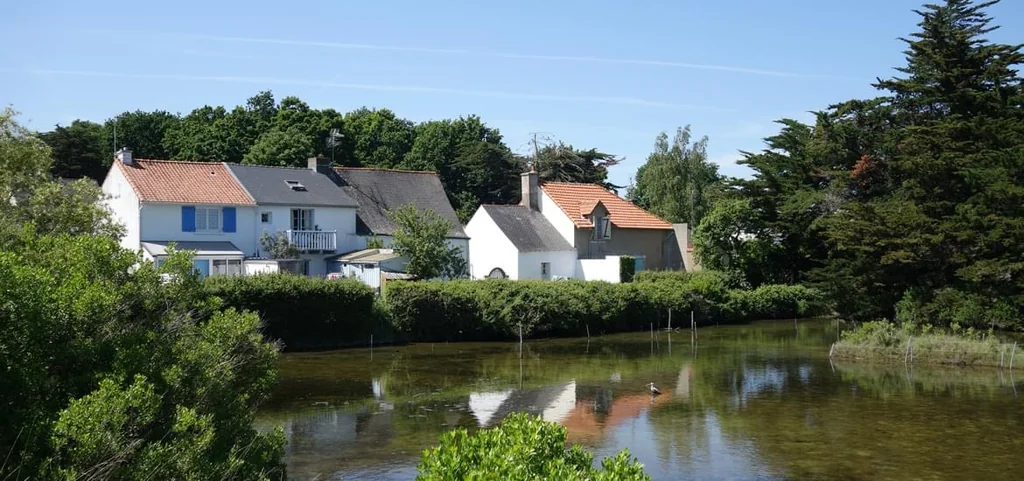 Maisons blanches du village de Kercabellec se reflétant dans le plan d'eau du traict