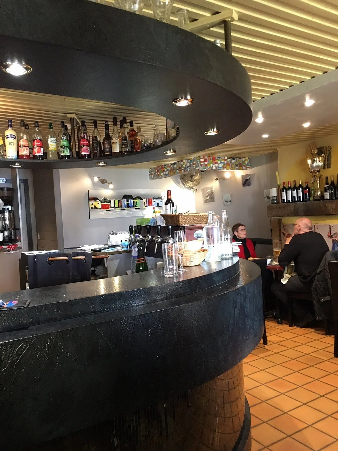Bar arrondi caractéristique et salle de La Godille avec mobilier soigné