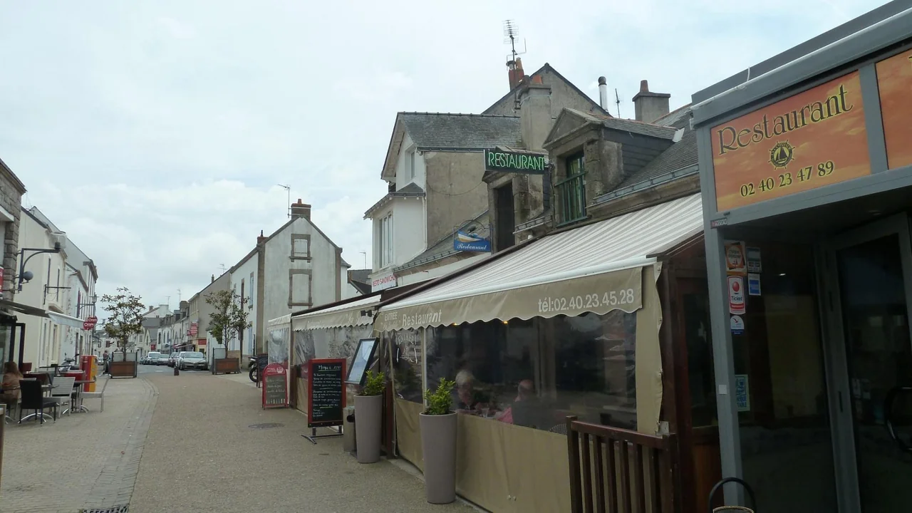 Façade et terrasse couverte de La Godille dans la rue piétonne de La Turballe