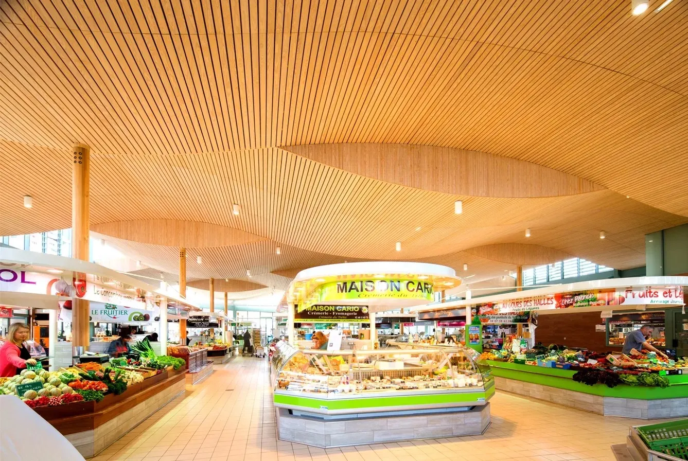 Intérieur des Halles de La Baule, plafond bois ondulé et étals de primeurs