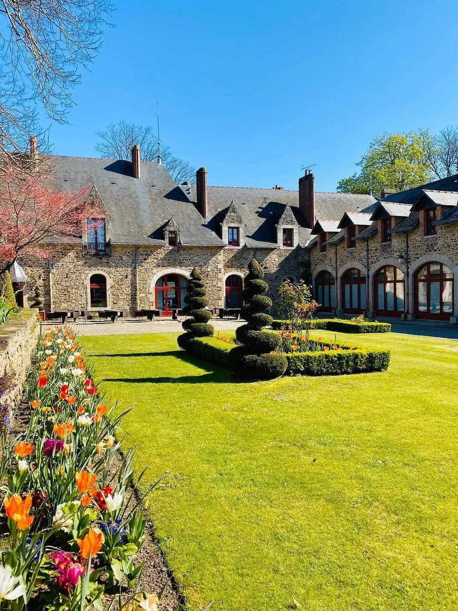 Cour intérieure du Domaine de la Bretesche avec jardins à la française et bâtiments en pierre