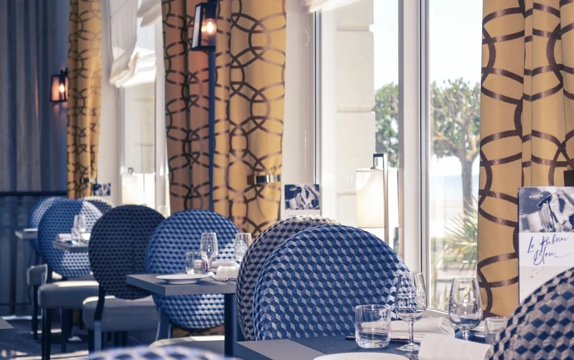 Salle du Ruban Bleu avec chaises bleues et or et vue sur la baie de La Baule