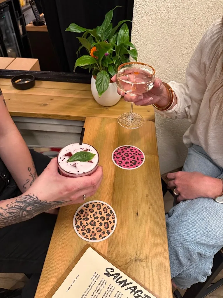 Cocktails du restaurant Sauvage à Pornichet sur table en bois avec sous-verres léopard et menu