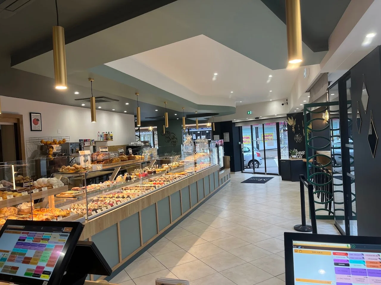 Intérieur lumineux de la boutique SY Martin avec longue vitrine de pâtisseries