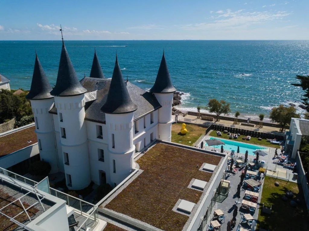 Vue rapprochée du Château des Tourelles à Pornichet avec ses tourelles d'ardoise, piscine et bord de mer