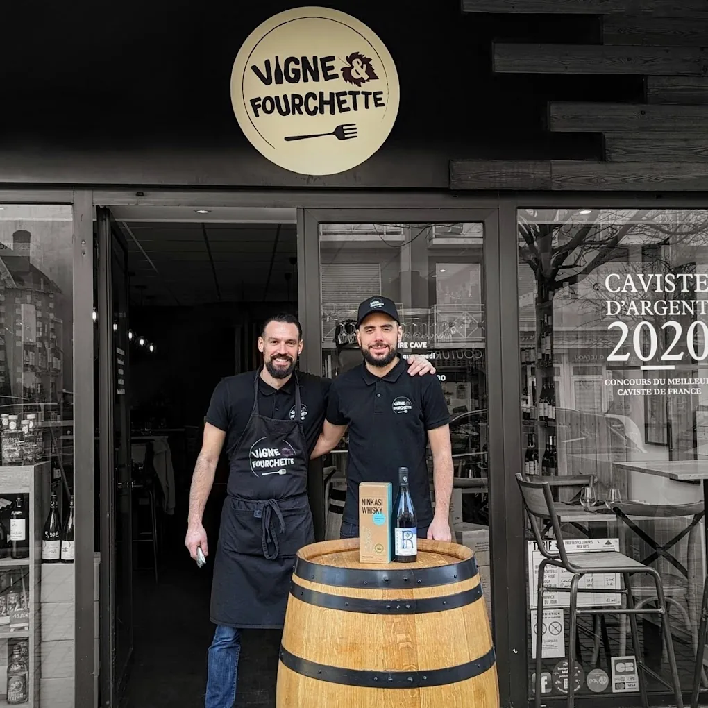L'équipe de Vigne & Fourchette devant la cave à manger avec un tonneau et une sélection de vins