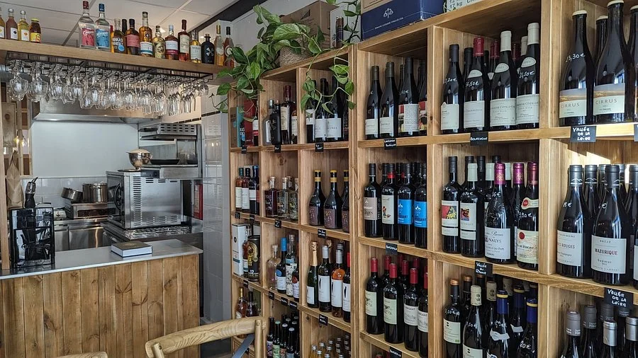 Étagères en bois avec les 150 références de vins de Vigne & Fourchette à La Baule
